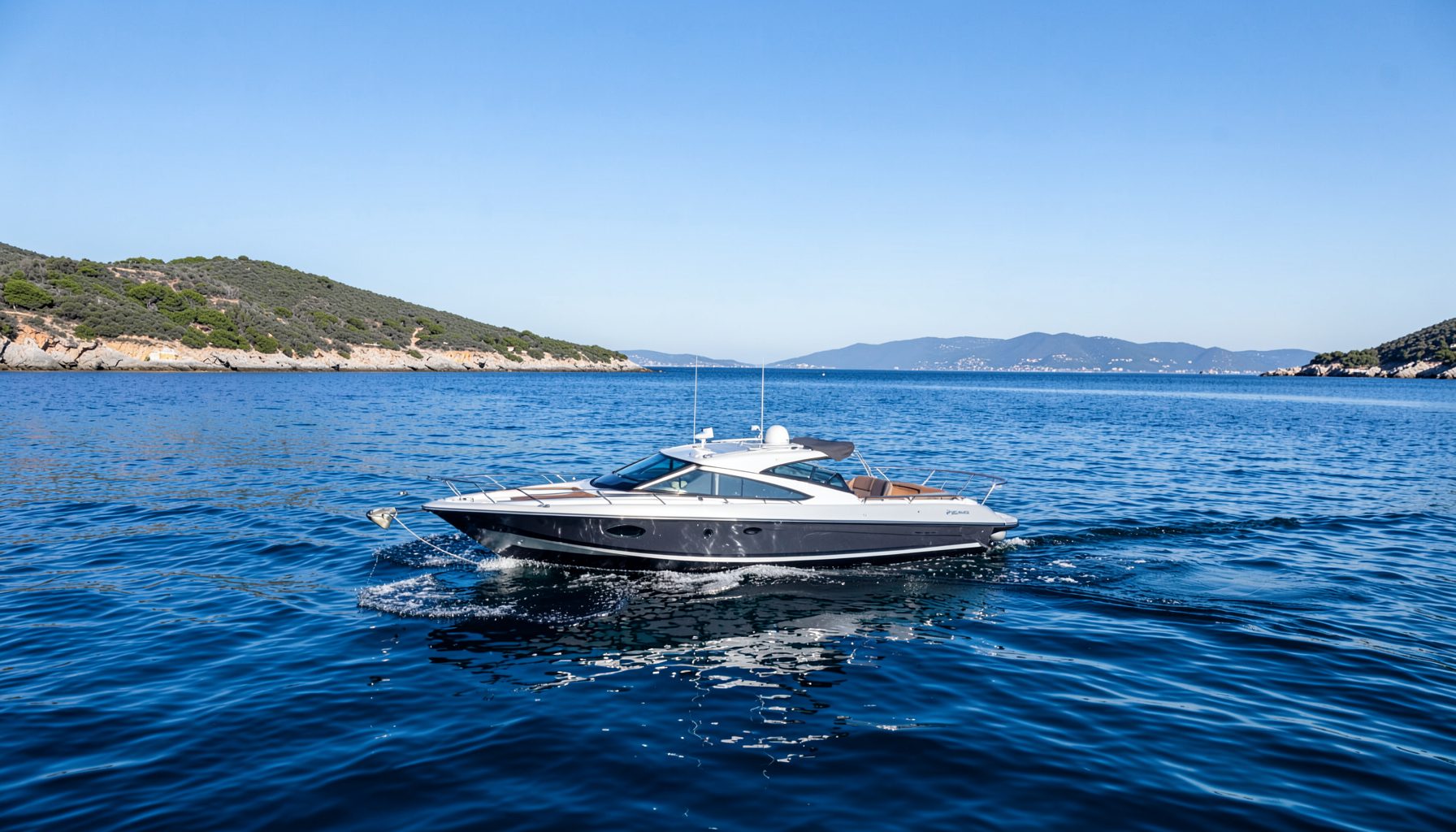 Modernes Motorboot gleitet bei klarem Himmel über tiefblaues Wasser, umgeben von einer ruhigen Küstenlandschaft