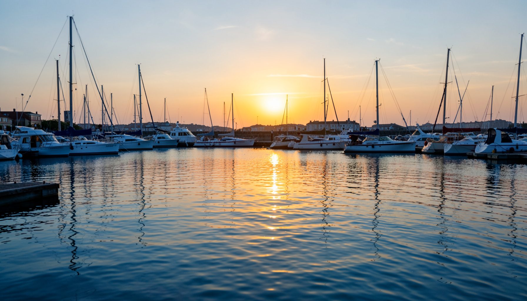 Ruhige Hafenszene bei Sonnenuntergang mit sanftem goldenem Licht auf dem Wasser, warme Blau- und Orangetöne